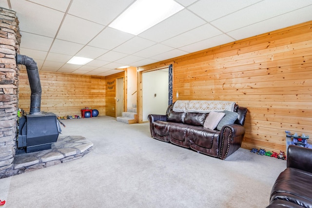 30 Knapp Ln, Kalispell, MT 59901 - living area with carpet, a wood stove, wood walls, and a paneled ceiling