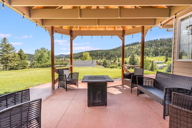 30 Knapp Ln, Kalispell, MT 59901 - view of patio featuring a mountain view, a fire pit, a wooded view, and a gazebo