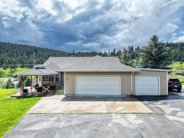30 Knapp Ln, Kalispell, MT 59901 - ranch-style house with a forest view, a front lawn, driveway, and roof with shingles