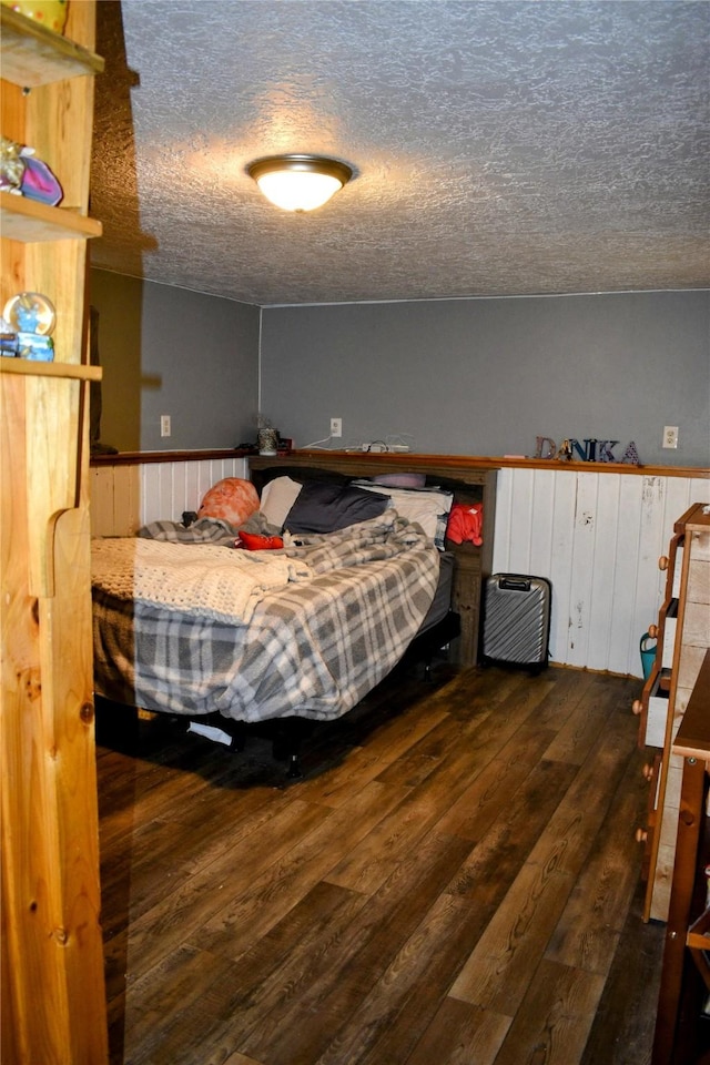 83 Indian Head Rd, Libby, MT 59923 - bedroom with a textured ceiling, a wainscoted wall, and wood-type flooring