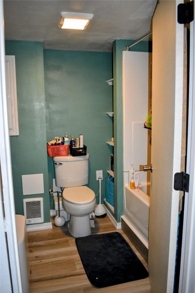 83 Indian Head Rd, Libby, MT 59923 - bathroom with toilet, wood finished floors,  shower combination, heating unit, and baseboards