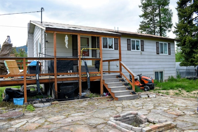 83 Indian Head Rd, Libby, MT 59923 - rear view of property featuring an outdoor fire pit, a wooden deck, and a patio area