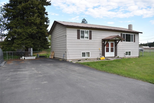 83 Indian Head Rd, Libby, MT 59923 - split foyer home with a chimney, asphalt driveway, and metal roof