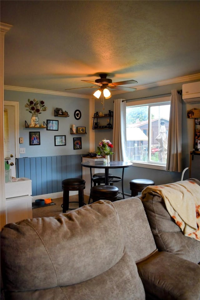 83 Indian Head Rd, Libby, MT 59923 - living room with a wall mounted air conditioner, a ceiling fan, ornamental molding, a wainscoted wall, and a textured ceiling