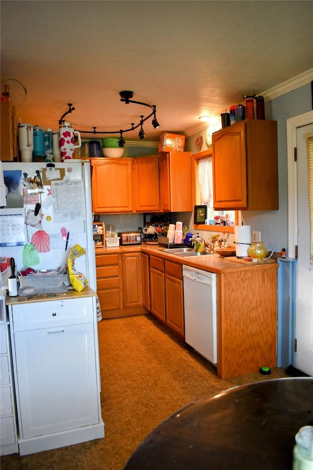 83 Indian Head Rd, Libby, MT 59923 - kitchen featuring dishwasher, a sink, crown molding, light countertops, and brown cabinets