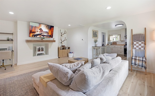 215 Tower St, Missoula, MT 59804 - living room with arched walkways, light wood-style flooring, recessed lighting, a fireplace, and baseboards