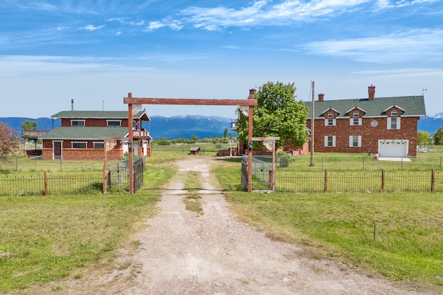 33562 Fox Rd, Polson, MT 59860 - view of dirt / gravel road featuring a gated entry, a gate, a view of countryside, and a mountain view