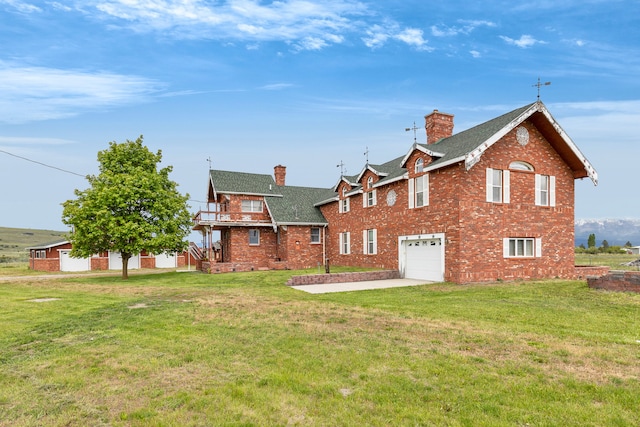 33562 Fox Rd, Polson, MT 59860 - back of property with a chimney, a shingled roof, a garage, brick siding, and concrete driveway