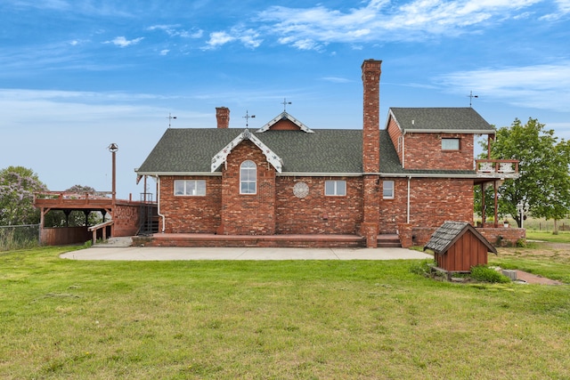 33562 Fox Rd, Polson, MT 59860 - back of property featuring roof with shingles, a patio, brick siding, and a chimney