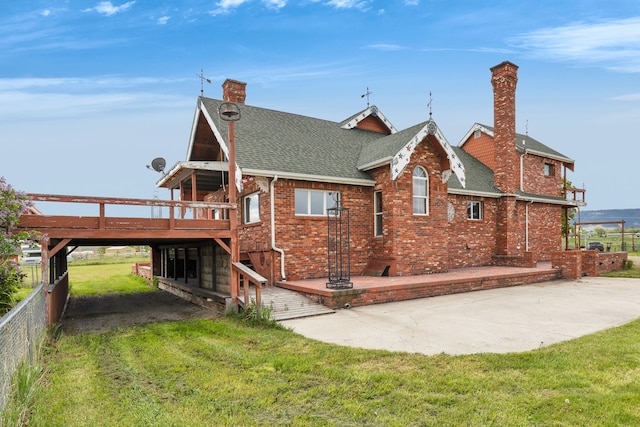 33562 Fox Rd, Polson, MT 59860 - view of side of property with a chimney, a patio area, a deck, a shingled roof, and brick siding