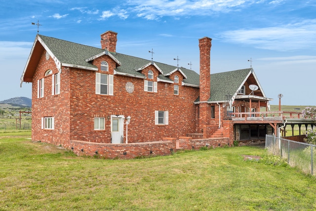 33562 Fox Rd, Polson, MT 59860 - back of property with a chimney, brick siding, a shingled roof, and a wooden deck