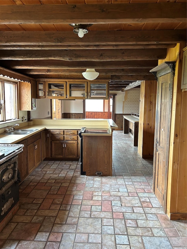 33562 Fox Rd, Polson, MT 59860 - kitchen featuring a peninsula, a sink, light countertops, brick floors, and wooden walls