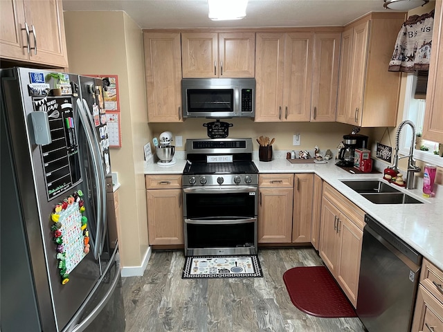 4239 7th Ave N, Great Falls, MT 59405 - kitchen featuring appliances with stainless steel finishes, a sink, light wood-type flooring, light brown cabinetry, and light countertops