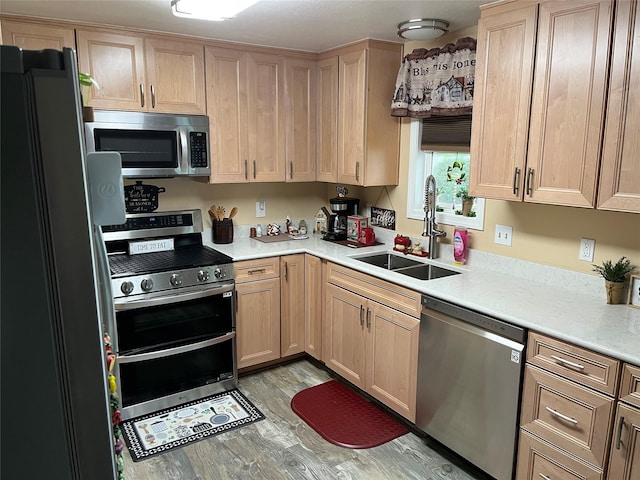 4239 7th Ave N, Great Falls, MT 59405 - kitchen with stainless steel appliances, light brown cabinets, a sink, light countertops, and light wood-type flooring