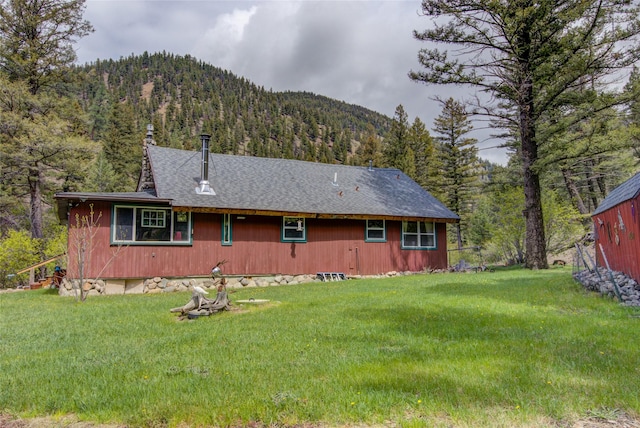 8229 York Rd, Helena, MT 59602 - rear view of property featuring a forest view, a mountain view, and a yard