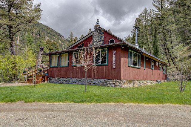 8229 York Rd, Helena, MT 59602 - view of side of property with a lawn, a mountain view, and a chimney