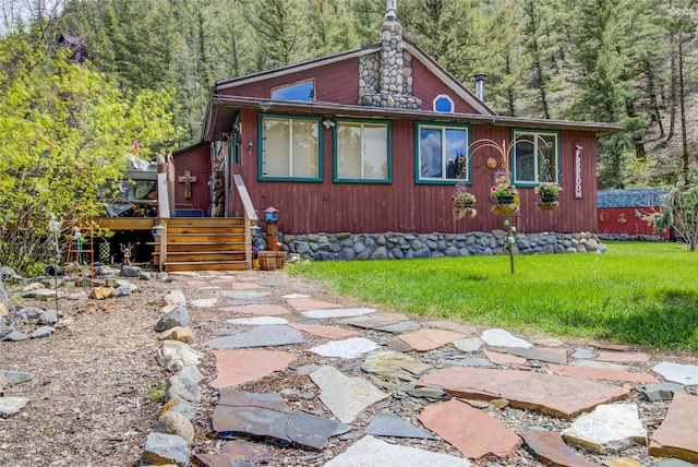 8229 York Rd, Helena, MT 59602 - view of front of house with a wooded view, a wooden deck, and a front yard