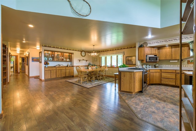 5380 US Highway 93, Conner, MT 59827 - kitchen featuring stainless steel appliances, a peninsula, a chandelier, brown cabinets, and dark wood-style floors