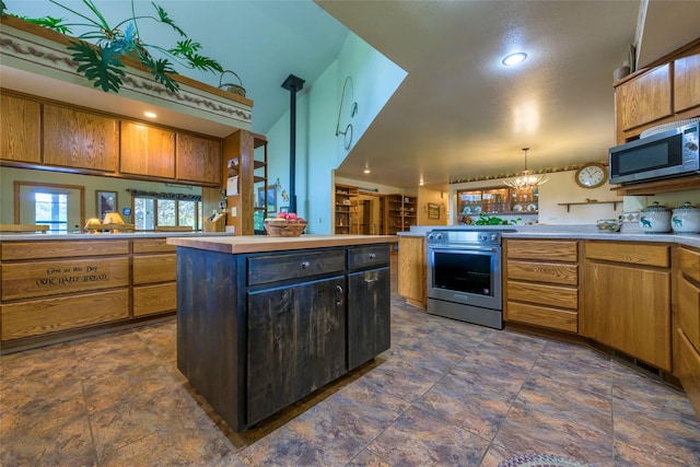 5380 US Highway 93, Conner, MT 59827 - kitchen featuring stainless steel appliances, a peninsula, light countertops, dark stone finish flooring, and hanging light fixtures