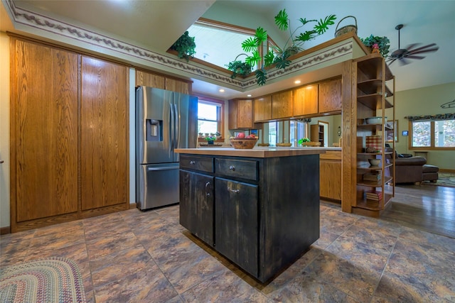 5380 US Highway 93, Conner, MT 59827 - kitchen with stainless steel fridge with ice dispenser, brown cabinetry, a kitchen island, light countertops, and dark stone finish floors