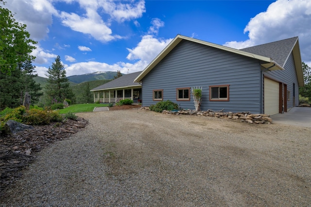 5380 US Highway 93, Conner, MT 59827 - rear view of house with dirt driveway, a mountain view, roof with shingles, and a garage