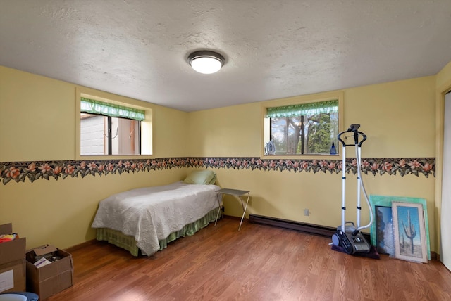 30 Panoramic Dr, Kalispell, MT 59901 - bedroom with wood finished floors, a textured ceiling, and a baseboard heating unit