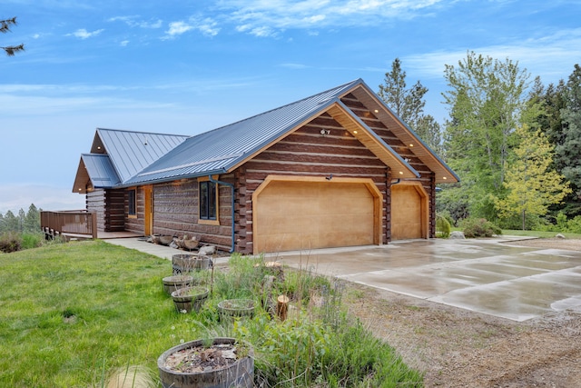 629 Alvista Loop, Hamilton, MT 59840 - log cabin featuring log siding, a garage, metal roof, concrete driveway, and a front lawn