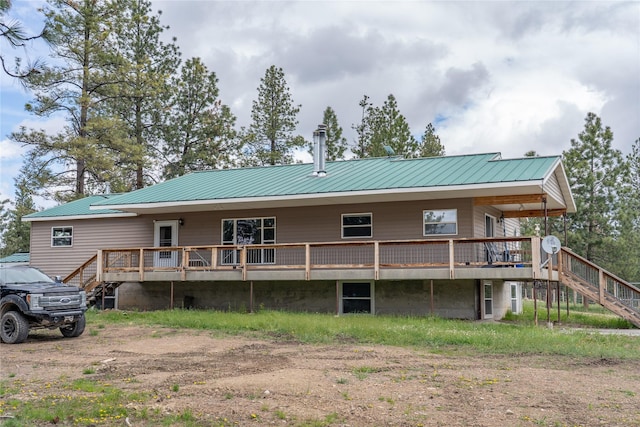 3185 Hubbart Dam Rd, Marion, MT 59925 - back of property featuring stairway, metal roof, a wooden deck, and a standing seam roof