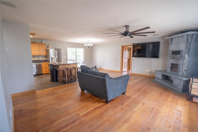 3185 Hubbart Dam Rd, Marion, MT 59925 - living room with light wood finished floors, a chandelier, ceiling fan, and baseboards