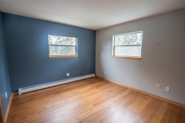 3185 Hubbart Dam Rd, Marion, MT 59925 - empty room featuring baseboard heating, plenty of natural light, hardwood / wood-style flooring, and baseboards