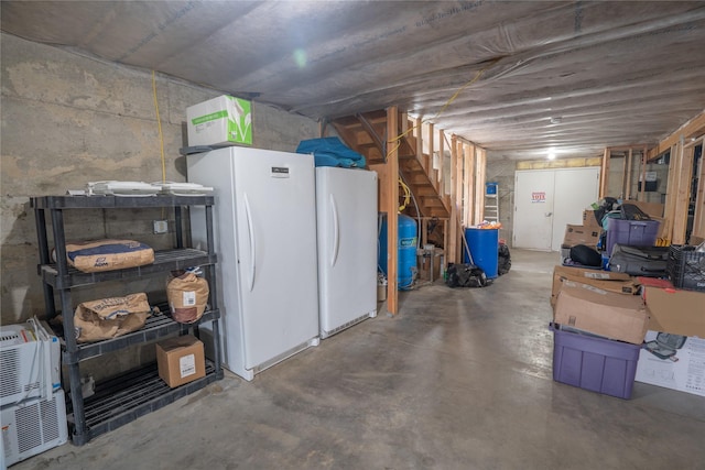 3185 Hubbart Dam Rd, Marion, MT 59925 - unfinished basement featuring freestanding refrigerator, stairway, and a water pressure tank