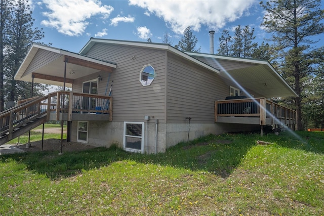3185 Hubbart Dam Rd, Marion, MT 59925 - rear view of property featuring stairs, a wooden deck, and a yard