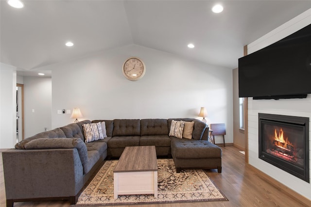 3870 Swan Rd, East Helena, MT 59635 - living area with a large fireplace, wood finished floors, vaulted ceiling, and recessed lighting