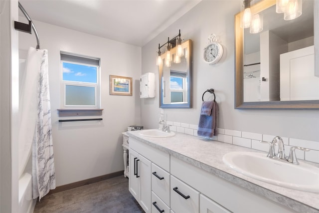 3870 Swan Rd, East Helena, MT 59635 - bathroom featuring double vanity, baseboards, shower / tub combo with curtain, and wood finished floors