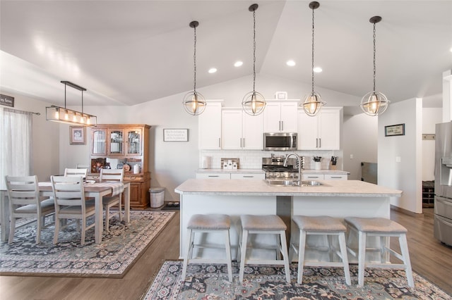 3870 Swan Rd, East Helena, MT 59635 - kitchen with stainless steel appliances, a sink, an island with sink, dark wood finished floors, and vaulted ceiling
