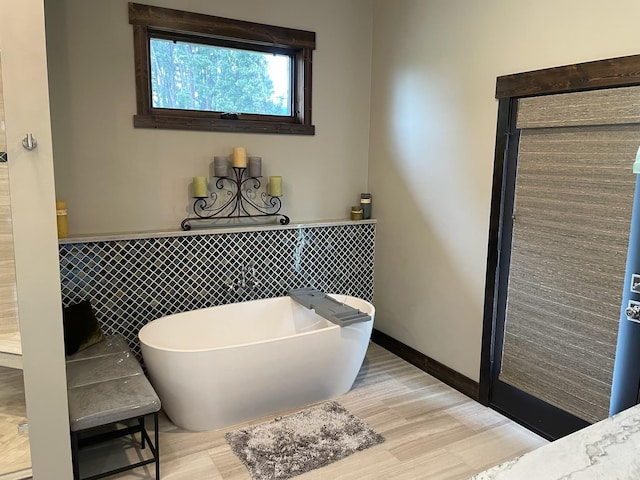 27 Elk Meadow Ln, Kalispell, MT 59901 - full bathroom with a freestanding bath, wood finished floors, tile walls, and wainscoting