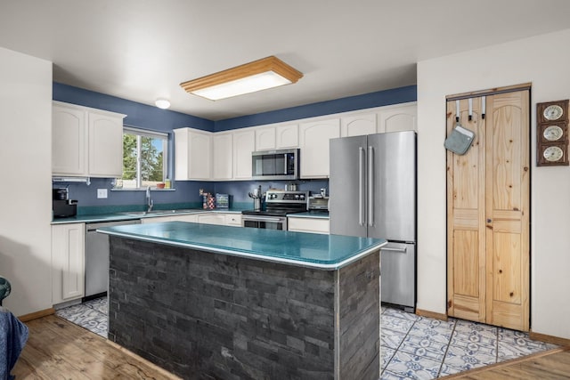5 Darlene Rd, Columbia Falls, MT 59912 - kitchen with stainless steel appliances, white cabinets, a center island, baseboards, and a sink