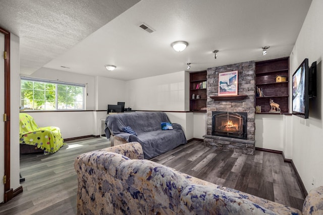 5 Darlene Rd, Columbia Falls, MT 59912 - living room featuring wood finished floors, baseboards, a stone fireplace, and a textured ceiling