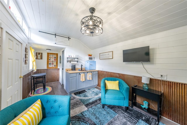 11537 Mt Highway 37 N, Libby, MT 59923 - living area featuring wooden walls, lofted ceiling, a barn door, wooden ceiling, and wood finished floors