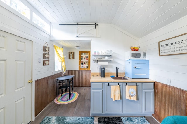 11537 Mt Highway 37 N, Libby, MT 59923 - kitchen featuring wooden walls, white microwave, a sink, healthy amount of natural light, and wood finished floors