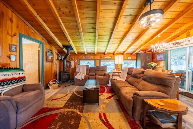 11537 Mt Highway 37 N, Libby, MT 59923 - living area featuring a chandelier, wood finished floors, plenty of natural light, a wood stove, and wood walls