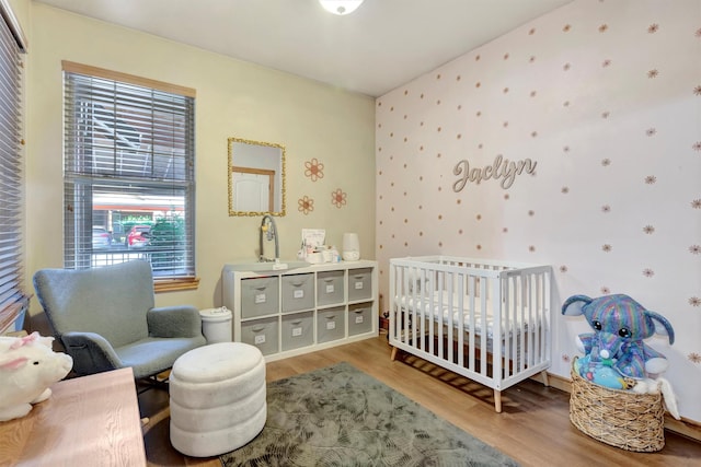 4100 Mullan Rd Unit 102, Missoula, MT 59808 - bedroom featuring wood finished floors, wallpapered walls, a crib, and a sink