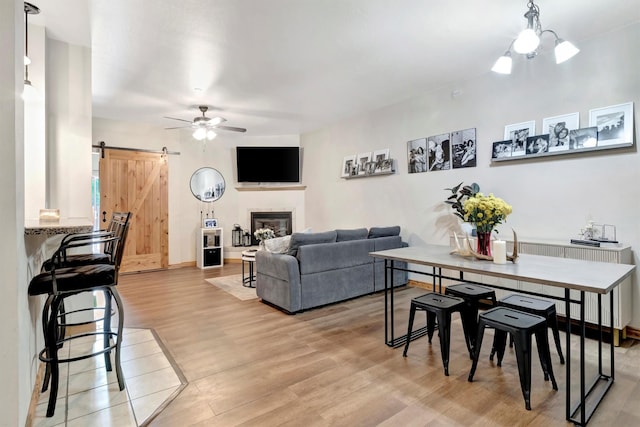 4100 Mullan Rd Unit 102, Missoula, MT 59808 - living area with a barn door, ceiling fan, light wood-style floors, and a glass covered fireplace