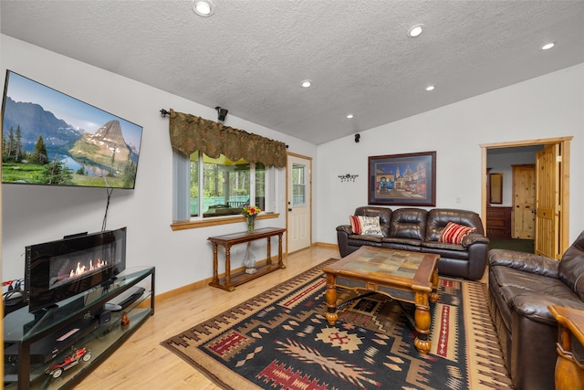 13033 Trinkus Ln, Bigfork, MT 59911 - living area with vaulted ceiling, a textured ceiling, wood finished floors, recessed lighting, and baseboards