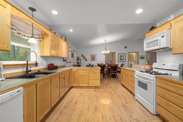 13033 Trinkus Ln, Bigfork, MT 59911 - kitchen with white appliances, a sink, a peninsula, light brown cabinetry, and vaulted ceiling
