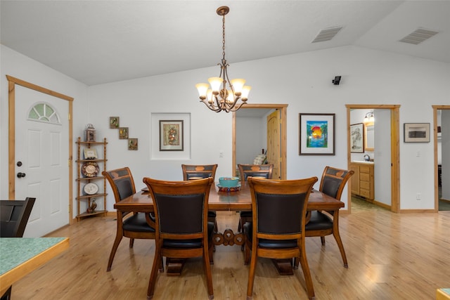 13033 Trinkus Ln, Bigfork, MT 59911 - dining room featuring vaulted ceiling, a chandelier, and light wood finished floors