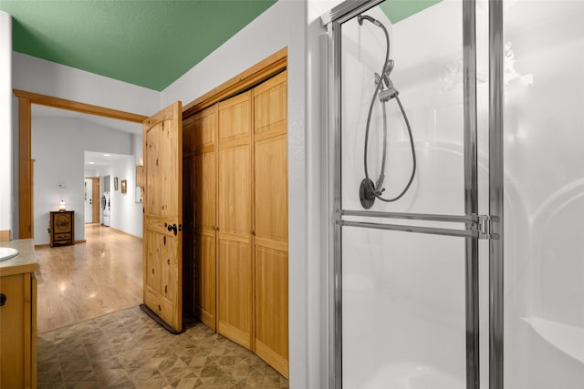 13033 Trinkus Ln, Bigfork, MT 59911 - bathroom with vanity, a shower stall, tile patterned floors, and washer / clothes dryer