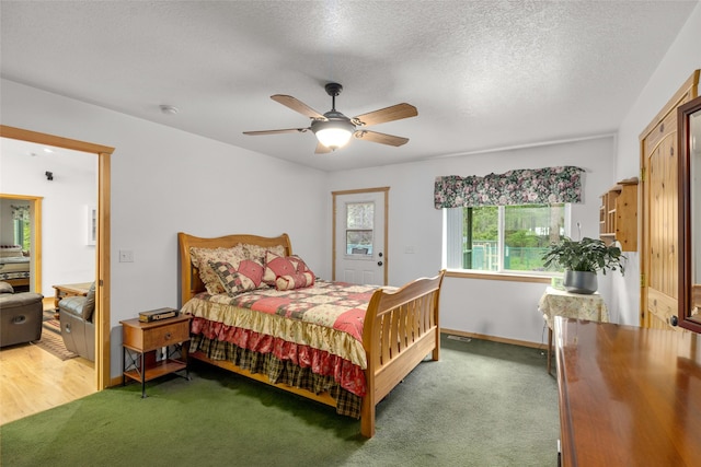 13033 Trinkus Ln, Bigfork, MT 59911 - bedroom with light carpet, ceiling fan, baseboards, and a textured ceiling
