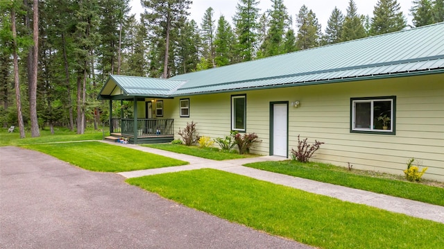 13033 Trinkus Ln, Bigfork, MT 59911 - view of front of home with covered porch, a front lawn, and metal roof
