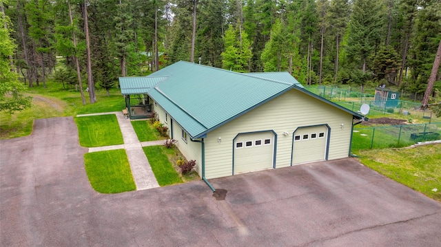 13033 Trinkus Ln, Bigfork, MT 59911 - garage with asphalt driveway and a view of trees